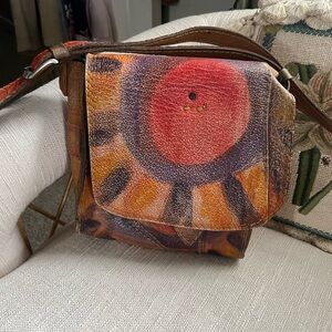 Beautifully worn  leather adjustable crossbody w/ Sun motif